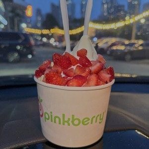Vaso con fresas frente a la ciudad
